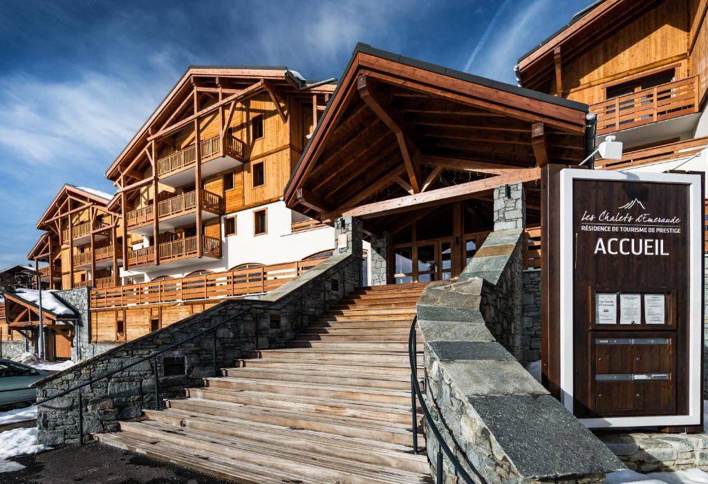 a building with a wooden staircase in front of it at Lagrange Vacances Les Chalets d'Emeraude in Hauteluce