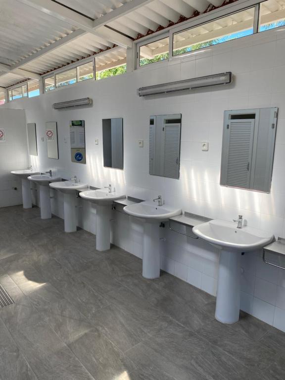 een badkamer met een rij wastafels en spiegels bij KT-0094 Magnífica Tienda Tipi - Camping Miramar Playa in Torredembarra