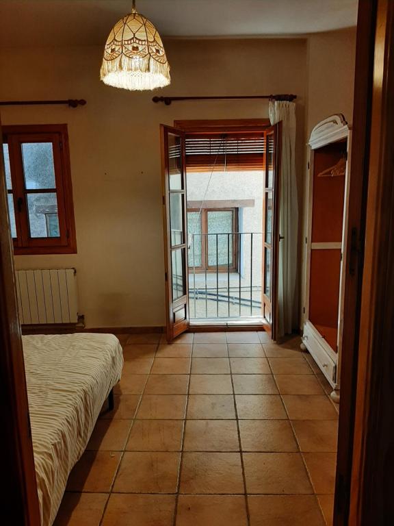 1 dormitorio con cama, ventana y lámpara de araña en Casa San Anton en Valderrobres
