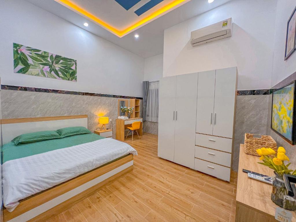 a bedroom with a king sized bed and a desk at Homestay Qhome in Con Dao