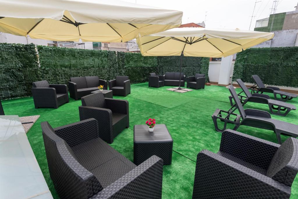 a patio with chairs and tables and umbrellas at Dream Palace in Bari