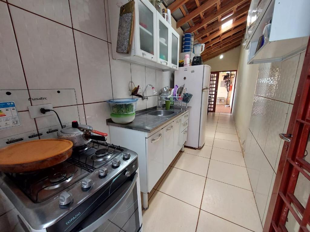 a small kitchen with a stove and a sink at MAZZAROTTO casa completa 2 quartos in Campo Grande