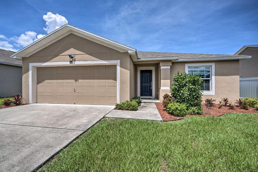 a house with a garage in the grass at Bright Cypress Gardens Home Near Legoland! in Cypress Gardens