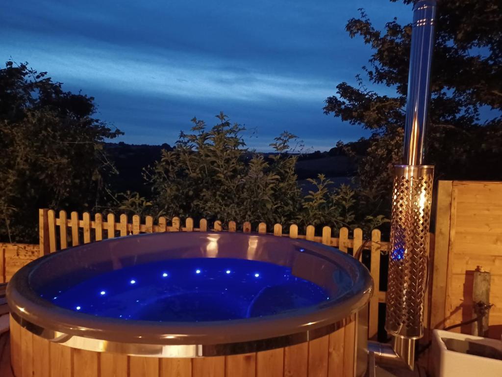 - un bain à remous dans l'arrière-cour la nuit dans l'établissement Norwell view farm glamping with hot tubs, à Bath