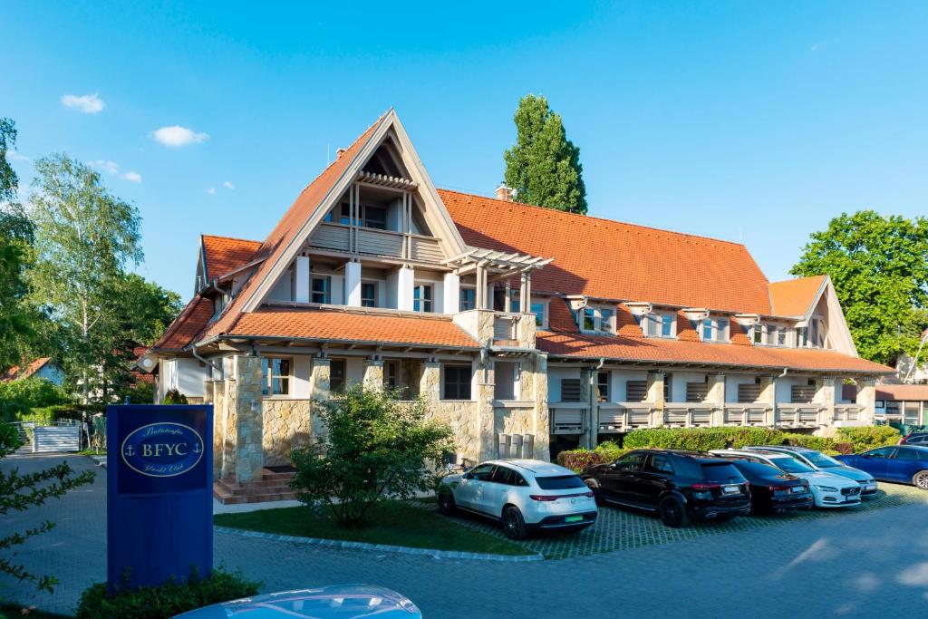 un edificio con coches estacionados frente a él en Balatonfői Yacht Club en Balatonkenese