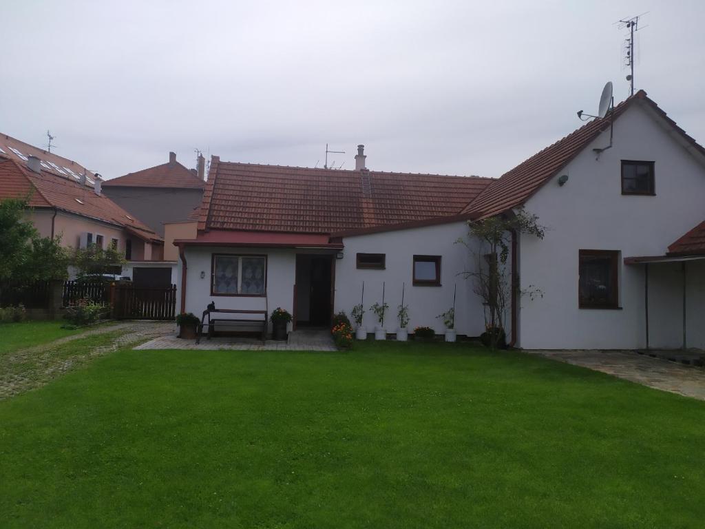 a white house with a green lawn in front of it at Ubytování U Jarky in Český Krumlov