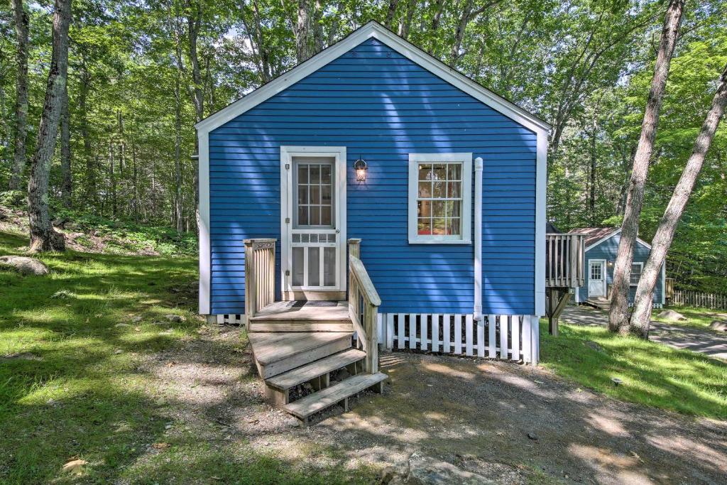 a blue tiny house in a yard with a staircase at Updated Tiny House Walk to Wiscasset Village in Edgecomb