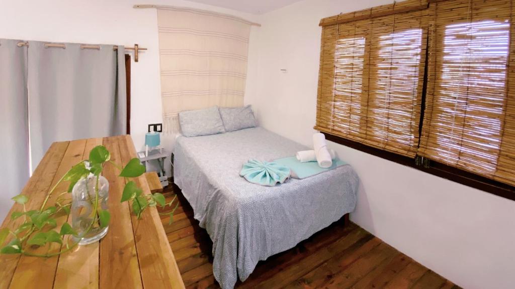 a small bedroom with a bed and a table at Casa Gonza by Holbox Rents in Holbox Island