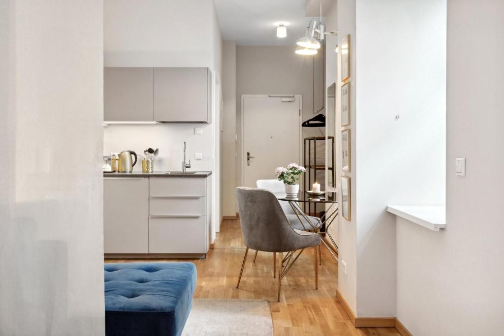 eine kleine Küche mit einem Tisch und einem blauen Stuhl in der Unterkunft Modern and new designer flat in Charlottenburg in Berlin