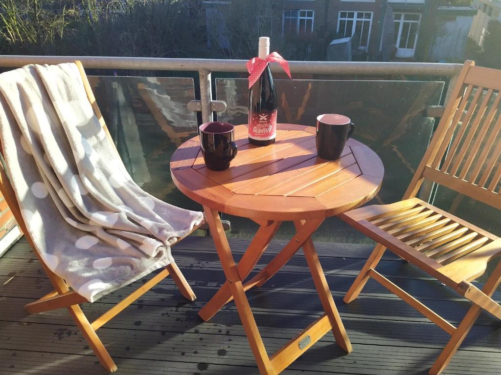 einen Tisch mit einer Flasche Wein und zwei Stühlen in der Unterkunft Villa MeerSinn in Bad Zwischenahn