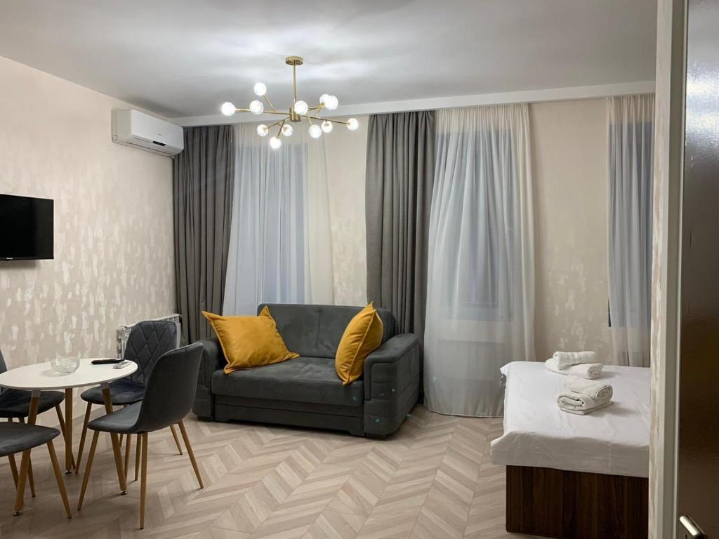 sala de estar con sofá y mesa en Home Plus Apartments en Tiflis