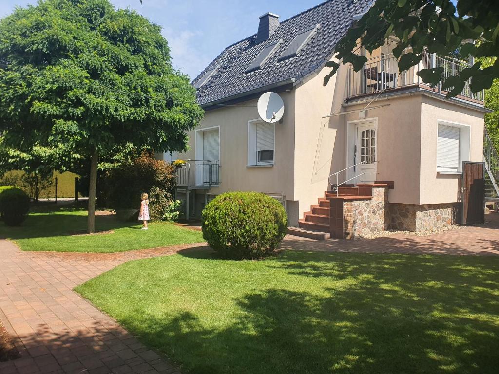 a little girl walking in front of a house at Ferienhaus in unberührter Natur mit zwei Schlafzimmern in Heideblick