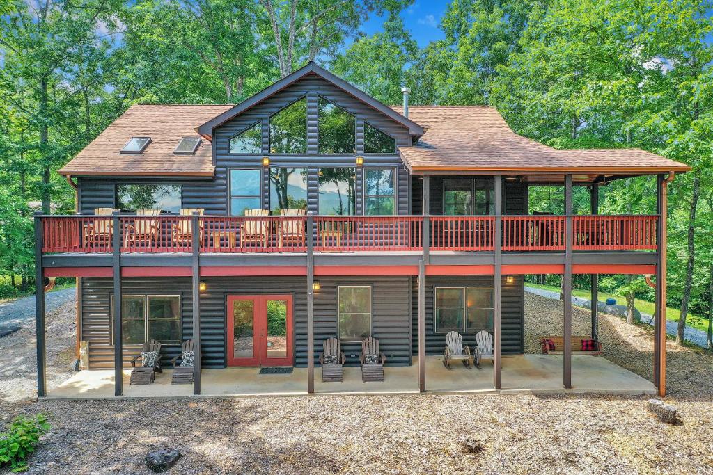 a house with a wrap around deck with chairs at Bear Cloud in Blue Ridge