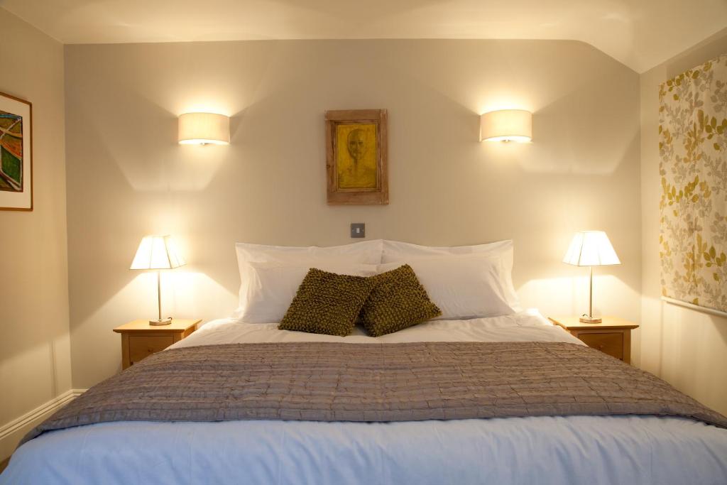 a bedroom with a large white bed with two lamps at Hay Retreats in Hay-on-Wye