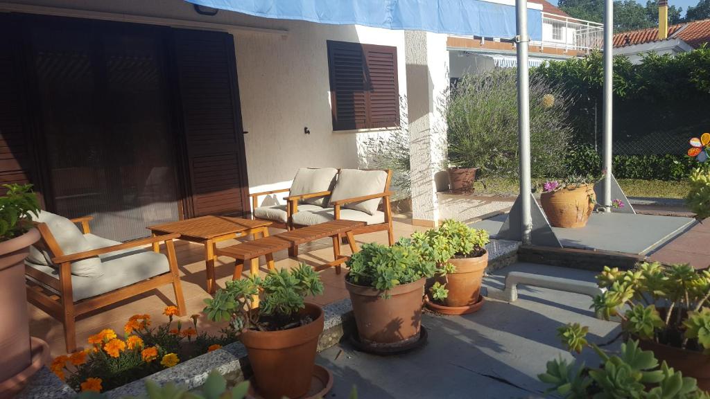 a patio with chairs and tables and potted plants at kuca za odmor Sisan in Šišan