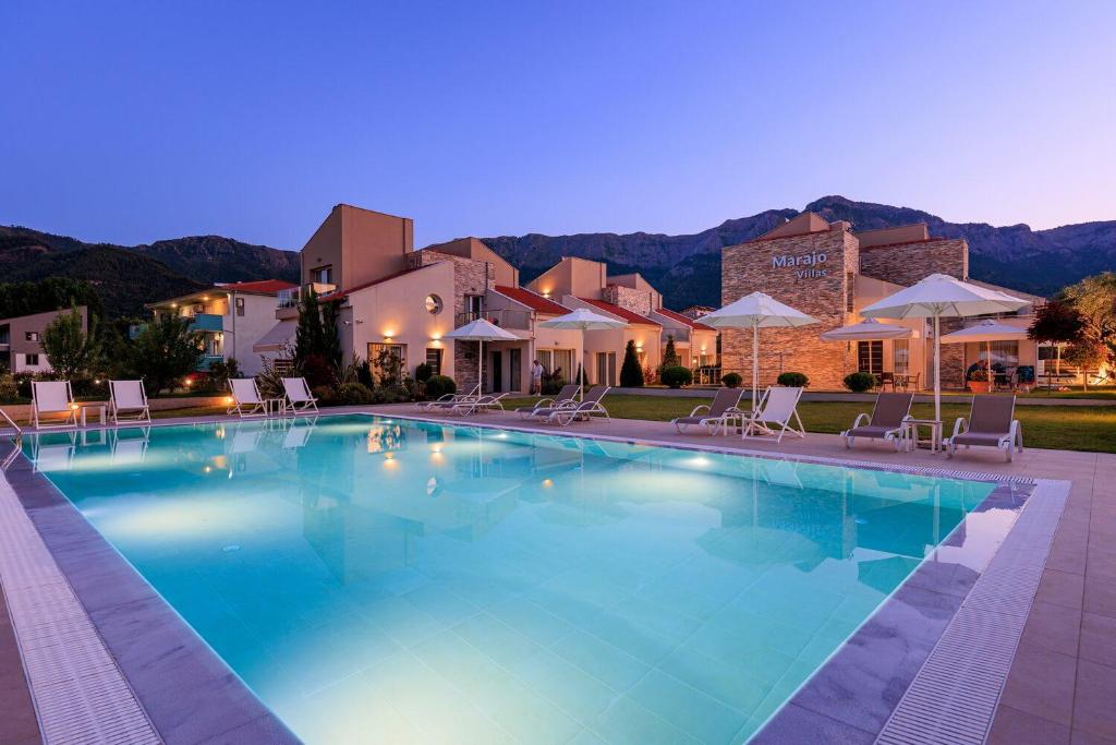 a large swimming pool with chairs and umbrellas at Villas Marajo in Skala Potamias