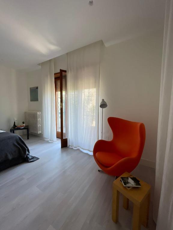 sala de estar con silla roja y cama en Sweet relax, en Cassino