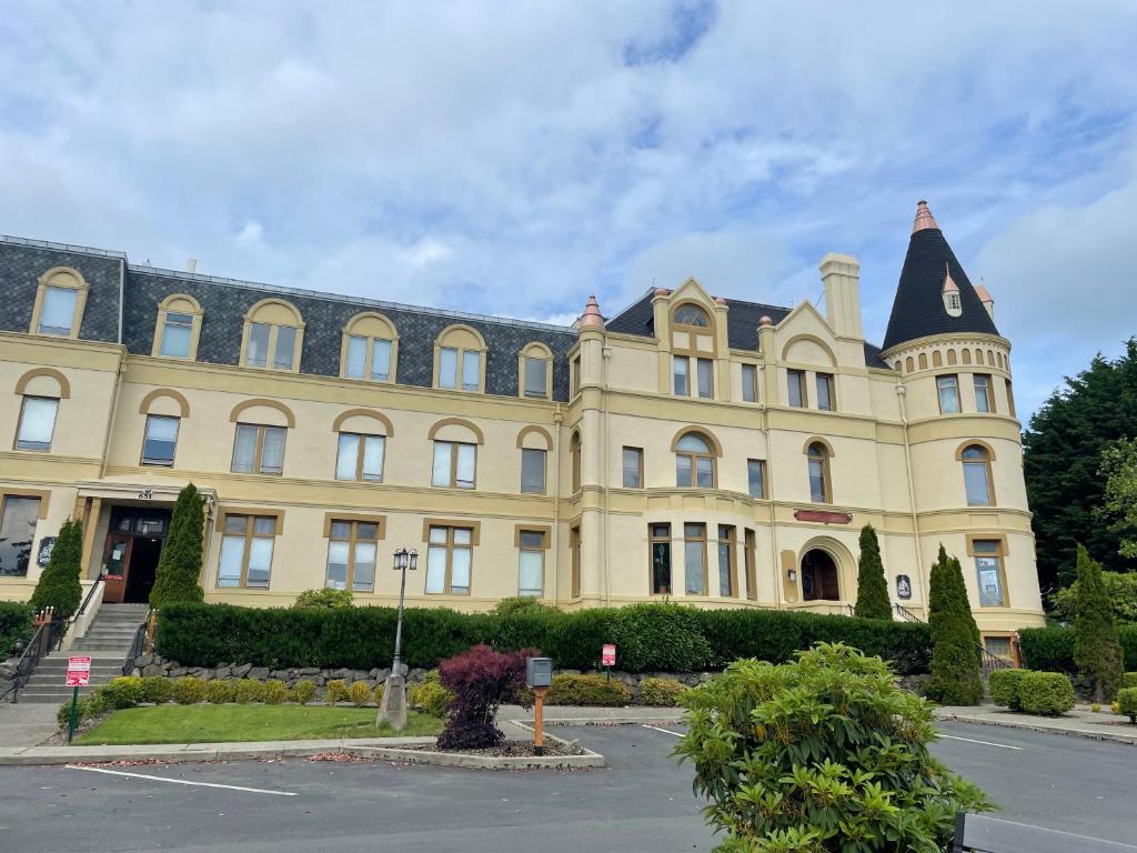 a large yellow building with a black roof at Manresa Castle in Port Townsend