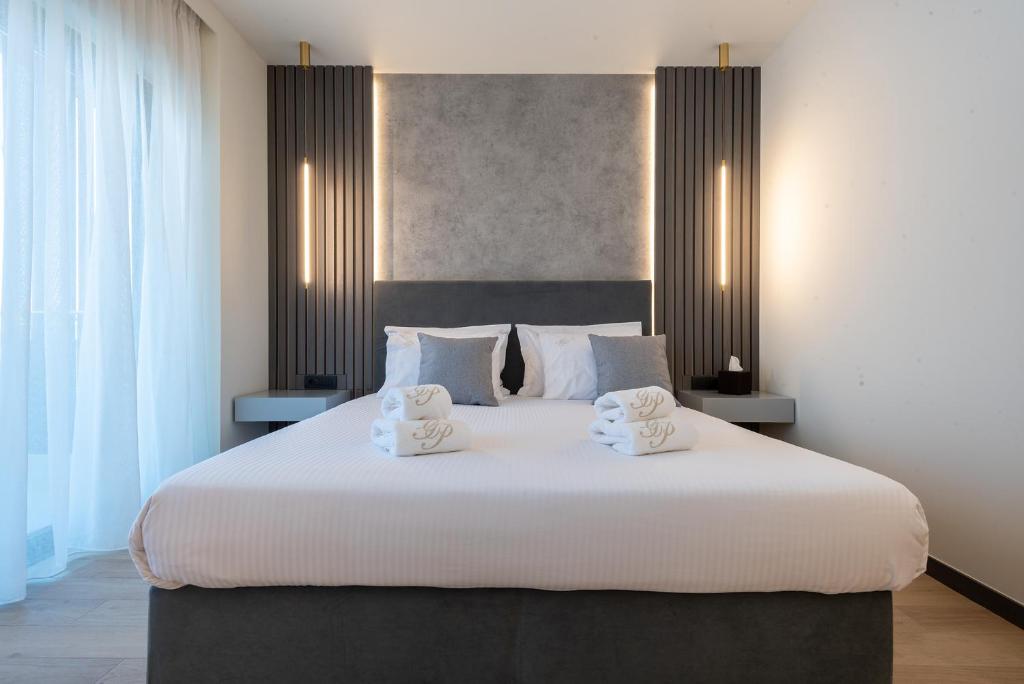 a bedroom with a large white bed with two towels at GRAND PATELLI in Myrina
