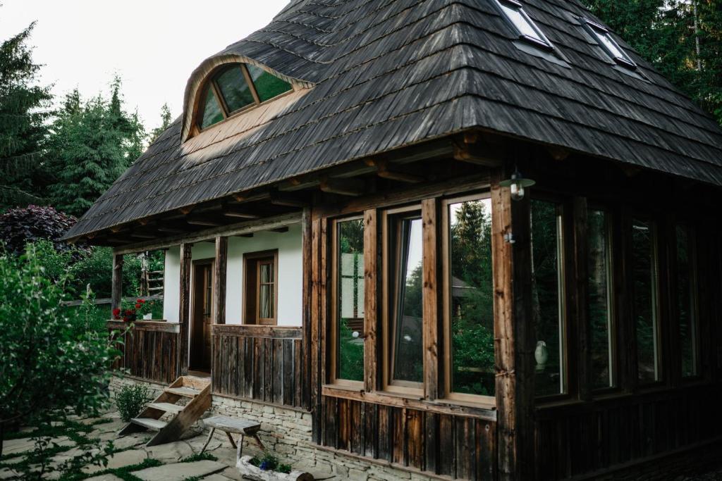 a small house with a gambrel roof at Casa de Vacanta Colibita Veche- langa lac in Colibiţa