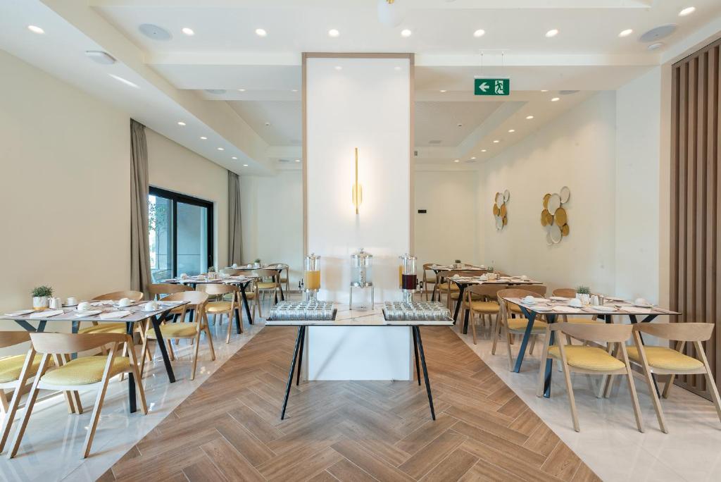 a restaurant with tables and chairs in a room at GRAND PATELLI in Myrina