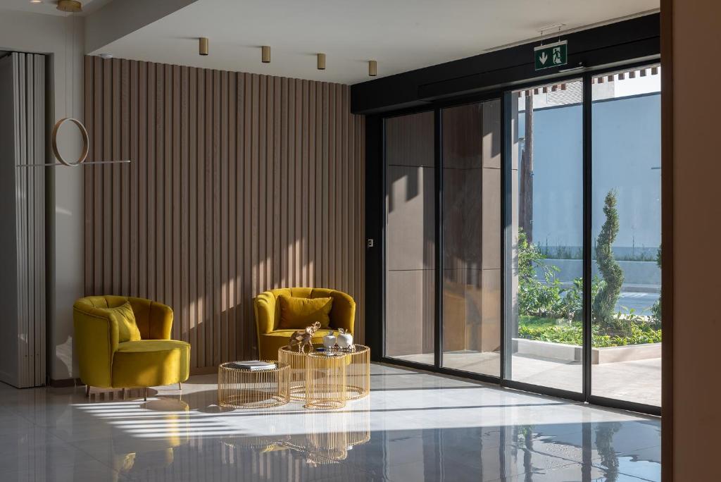 a lobby with two yellow chairs and a glass table at GRAND PATELLI in Myrina