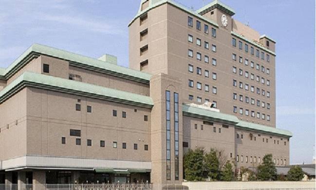 un grand bâtiment avec une horloge en haut dans l'établissement Hotel Higashinihon Utsunomiya, à Utsunomiya