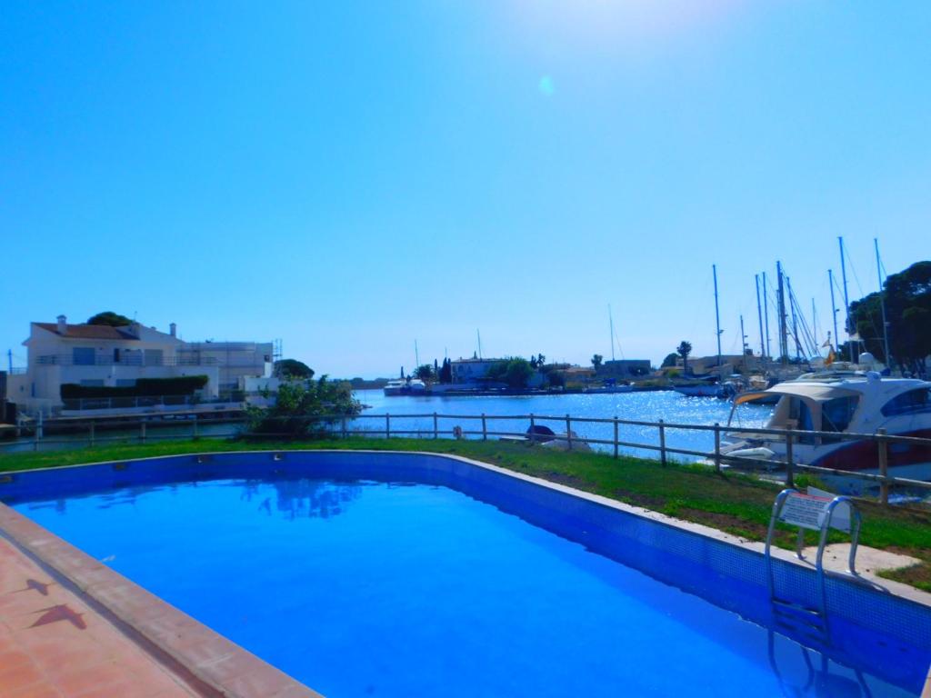 una piscina con vista su un porto turistico di GMID IMMO A222 Gregal Piso 2 habitaciones, parking y piscina a Roses