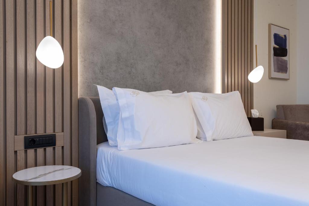 a bedroom with a bed with white sheets and pillows at GRAND PATELLI in Myrina