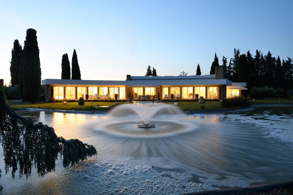 un bâtiment avec une fontaine en face d'un bâtiment dans l'établissement The baroque villa linked to modernity near Nîmes - by feelluxuryholidays, à Nîmes