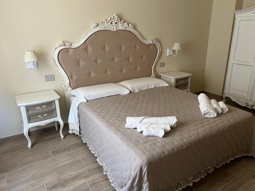 - une chambre avec un grand lit et des serviettes dans l'établissement La Perla del Borgo B&B, à Pise