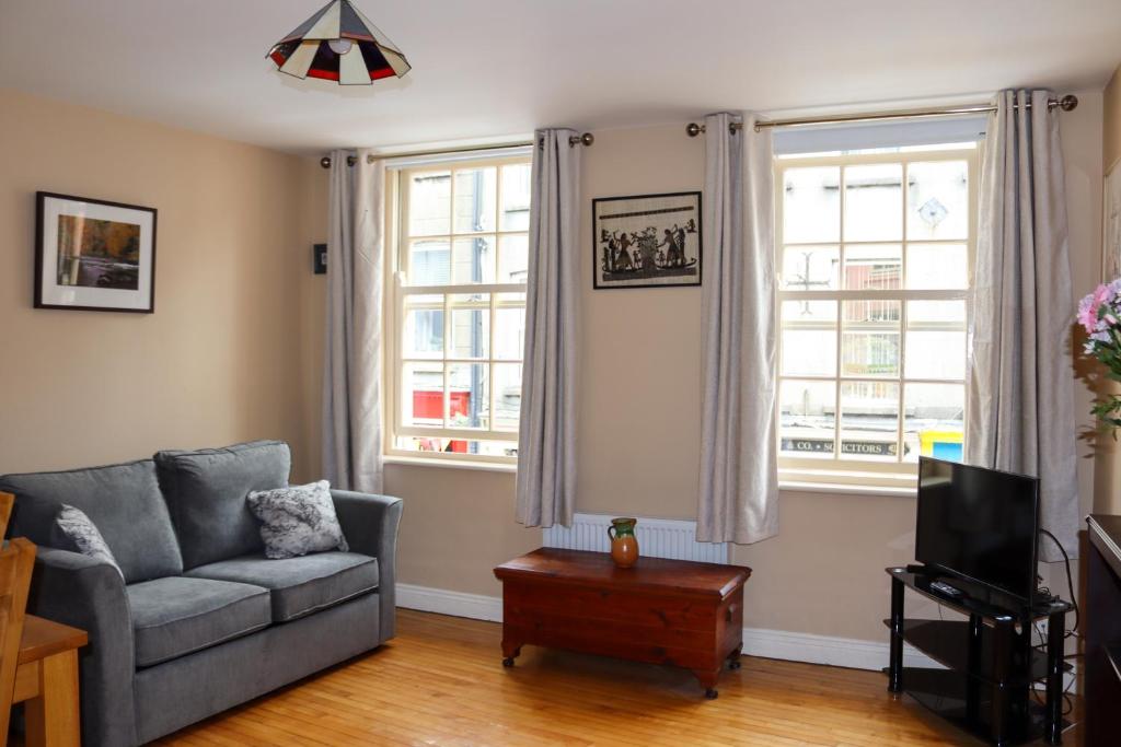 a living room with a couch and two windows at Ashe Street in Clonakilty