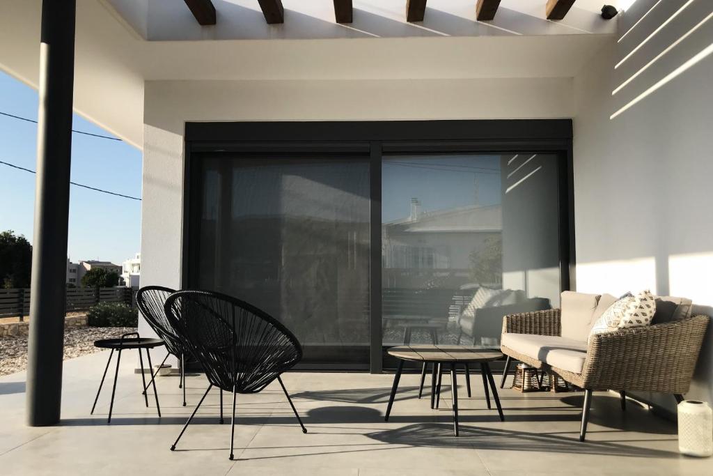 a patio with chairs and a couch and a table at Casa Lagada Kos Private Residence. in (( Kermetés ))