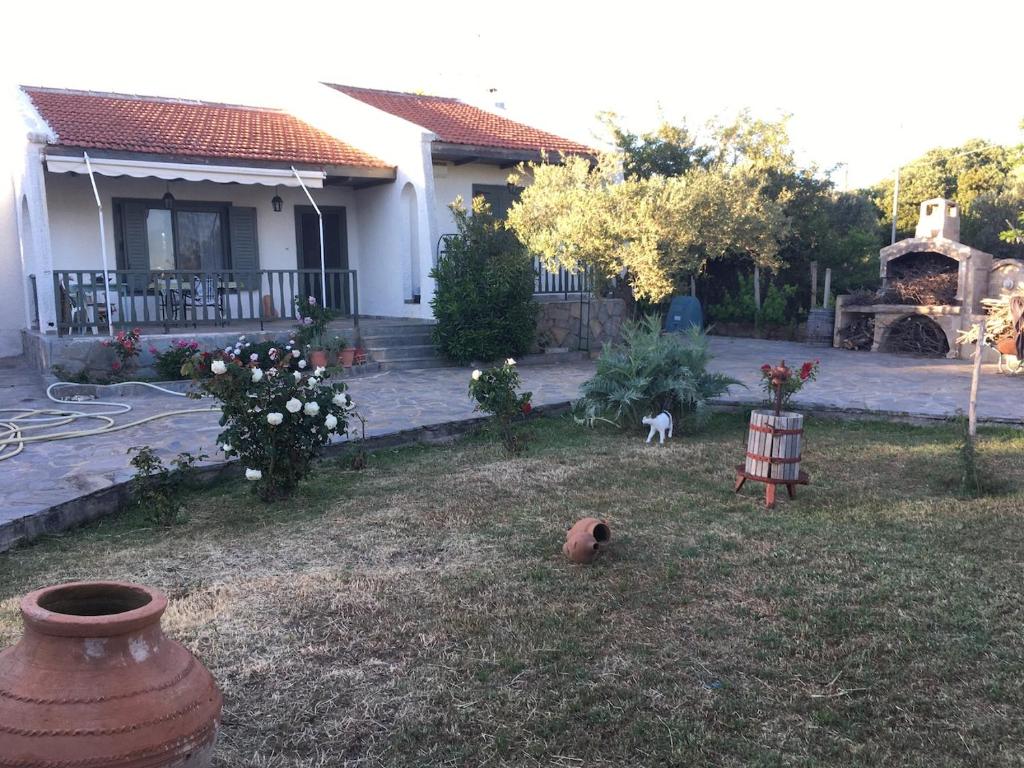 a yard with a large vase in front of a house at Vintage Beach House in Alexandroupoli
