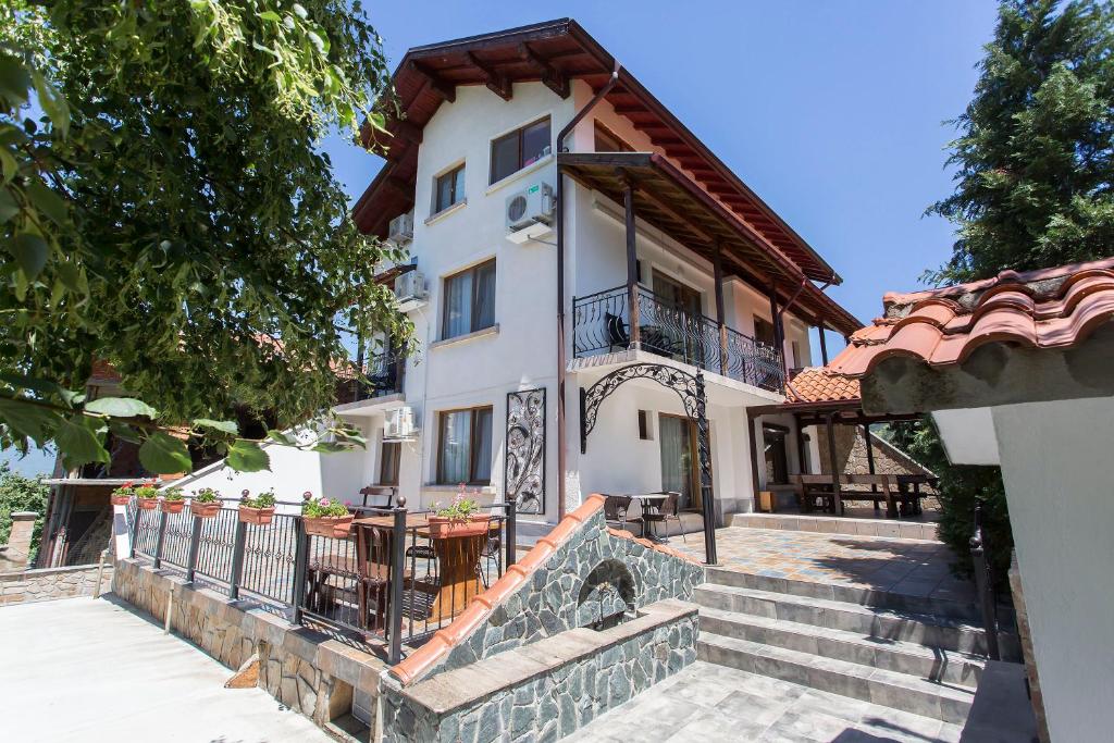 una casa blanca con una escalera que conduce a ella en Къща за гости Перуника, en Sapareva Banya