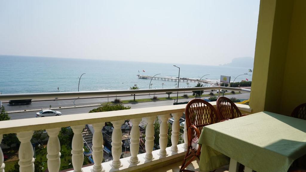 a balcony with a table and chairs and a view of the ocean at Orange Grove Apart Hotel in Alanya