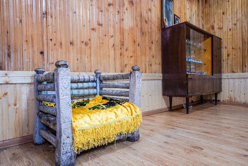a bed in a room with a wooden wall at Bori's Guesthouse in Ushguli