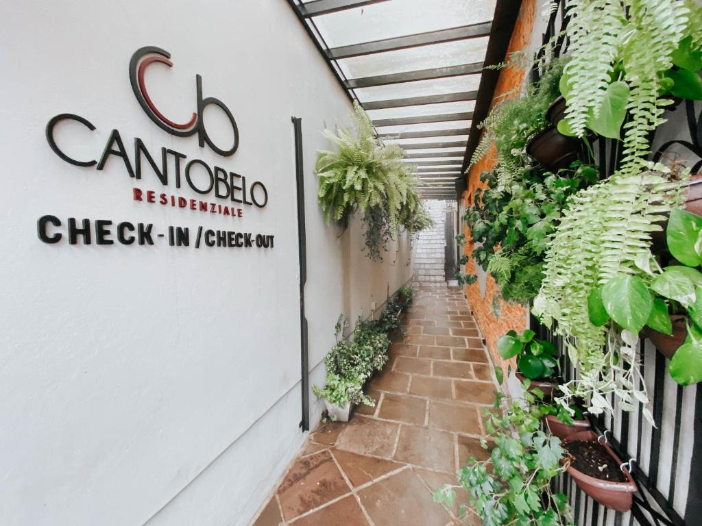 um sinal para um restaurante com plantas na parede em Canto Belo Residenziale em Gramado