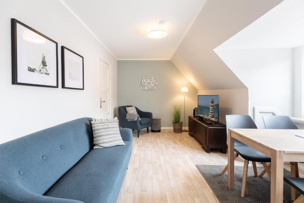 ein Wohnzimmer mit einem blauen Sofa und einem Tisch in der Unterkunft Tante Tine in Husum