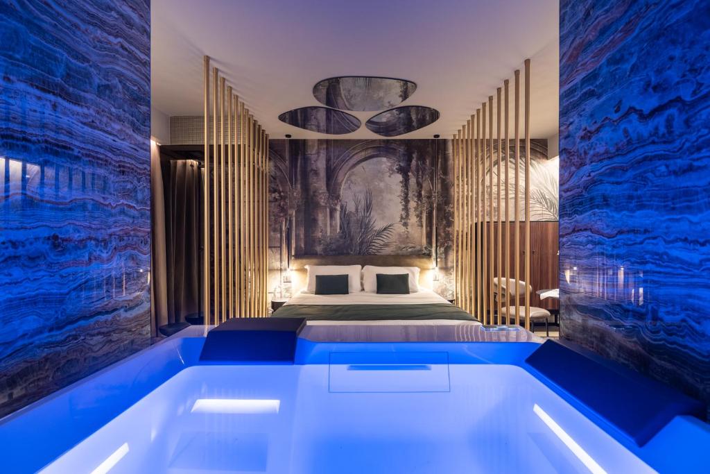 een slaapkamer met een groot bad voor een bed bij Aquasuite in Palermo
