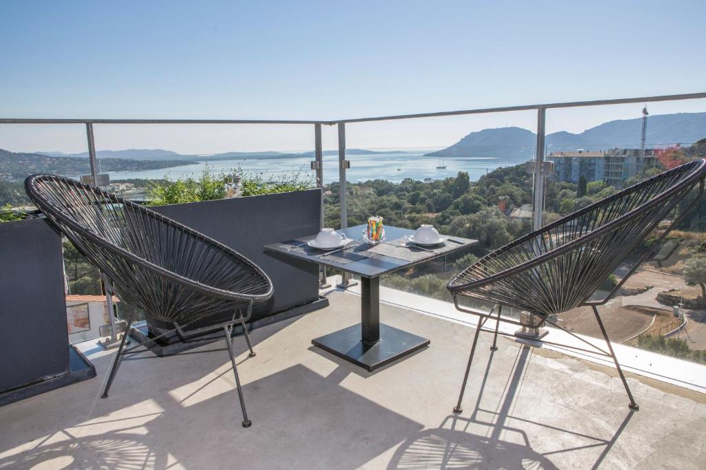 einen Tisch und zwei Stühle auf einem Balkon mit Aussicht in der Unterkunft Hotel Alcyon in Porto-Vecchio