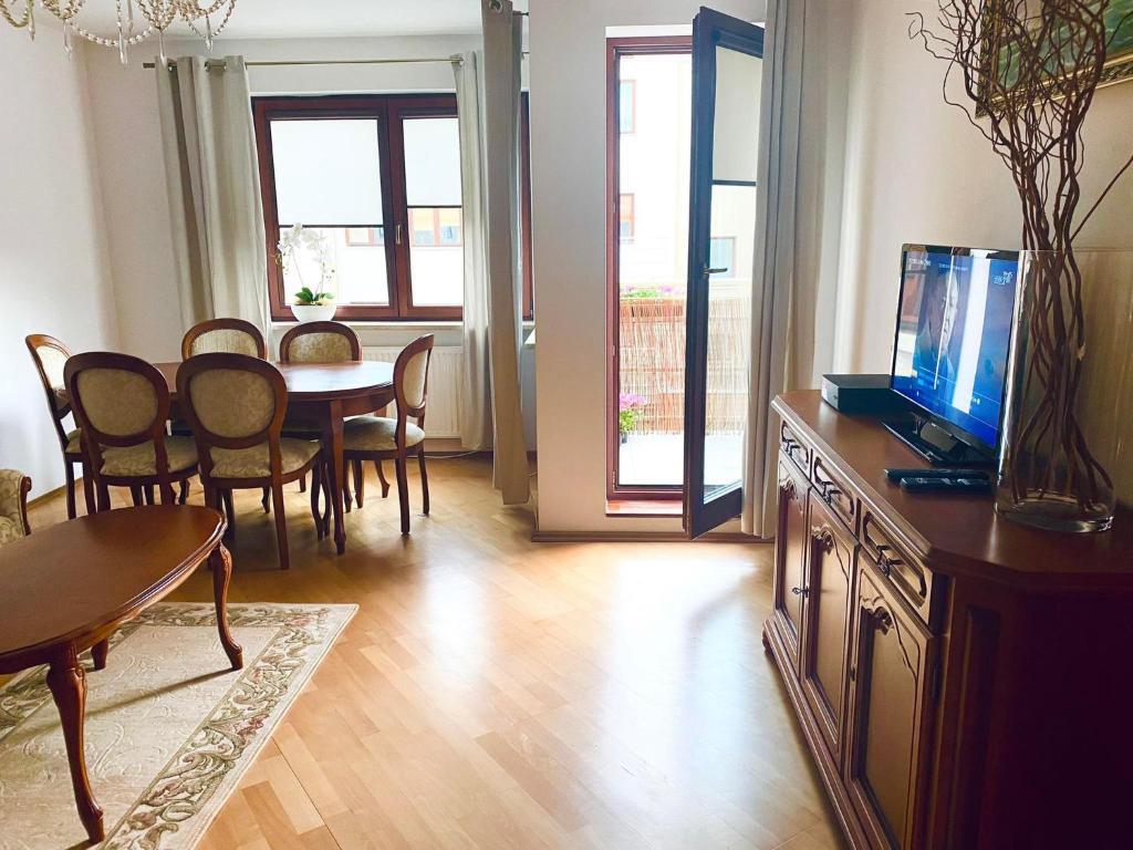 salon ze stołem jadalnym i telewizorem w obiekcie Wakacyjny Apartament blisko plaży. w Gdańsku