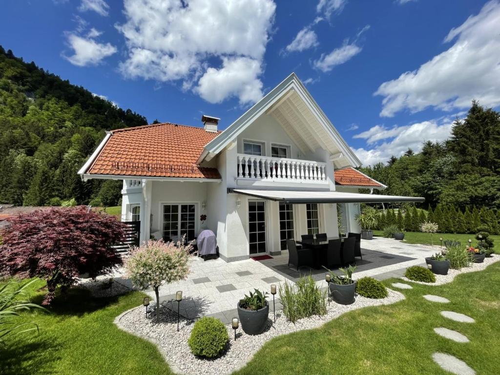 une maison blanche avec un toit rouge dans l'établissement Apartment Tinney, à Kössen