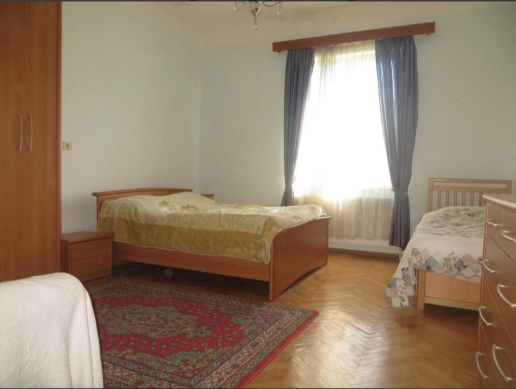 1 Schlafzimmer mit 2 Betten und einem Fenster in der Unterkunft Family Guest House Marso in Ssatschcheri