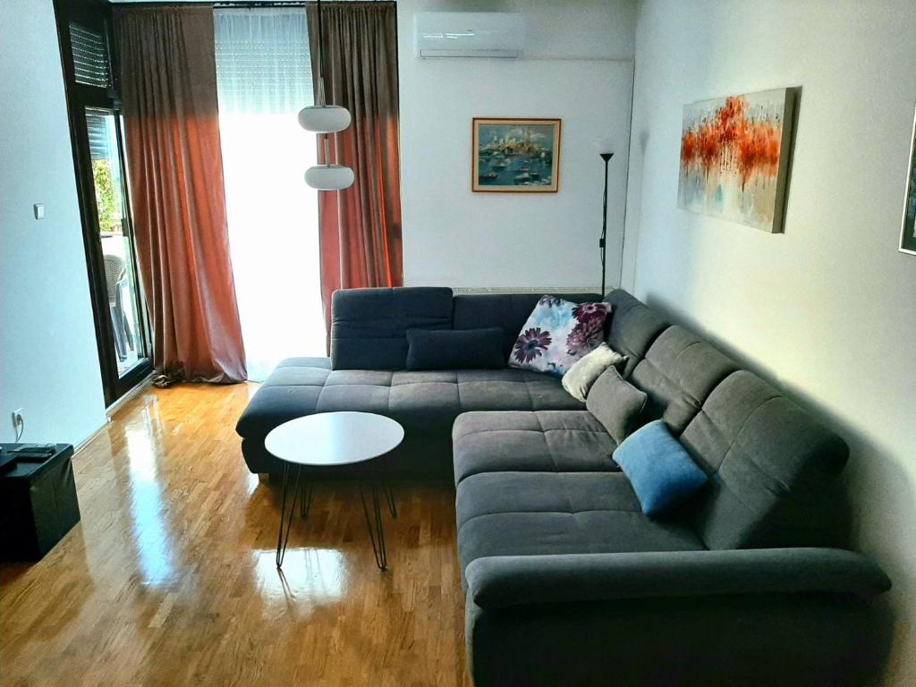 ein Wohnzimmer mit einem Sofa und einem Tisch in der Unterkunft Maximus 2 in Čakovec