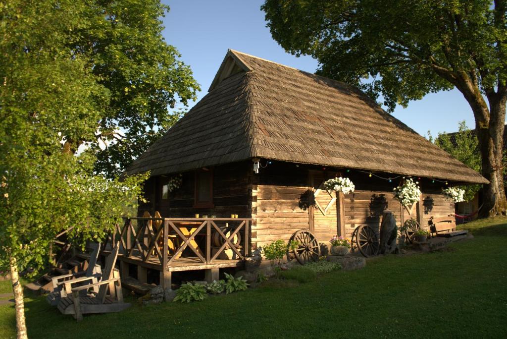 a large wooden cabin with a roof at Sodyba BIČIULIŲ NAMAI in Plateliai