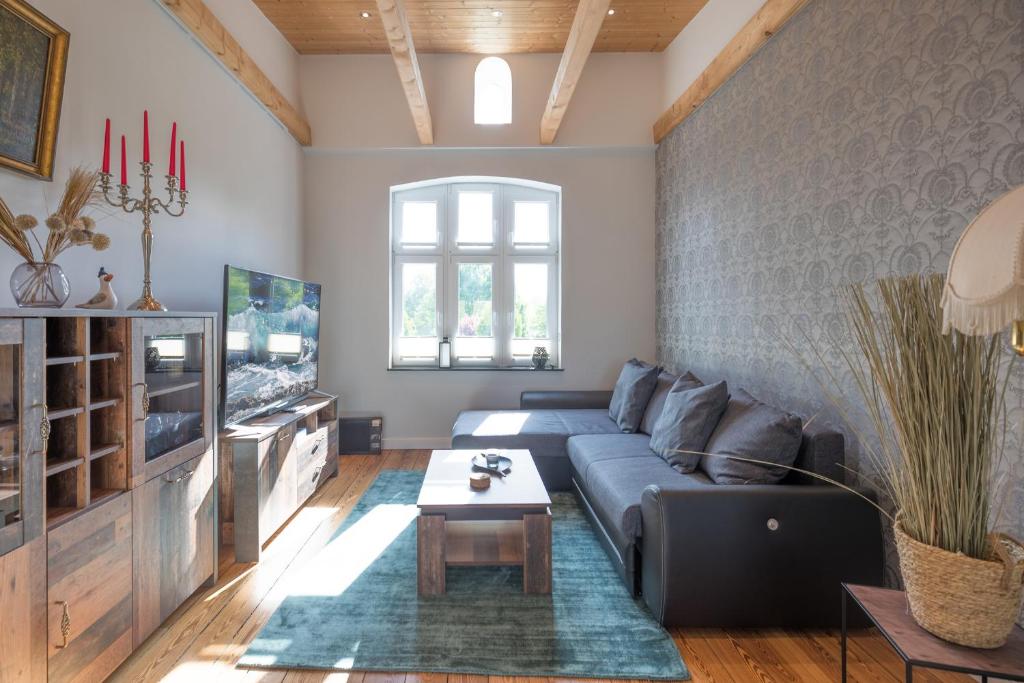 sala de estar con sofá y TV en Quartier 41, en Husum