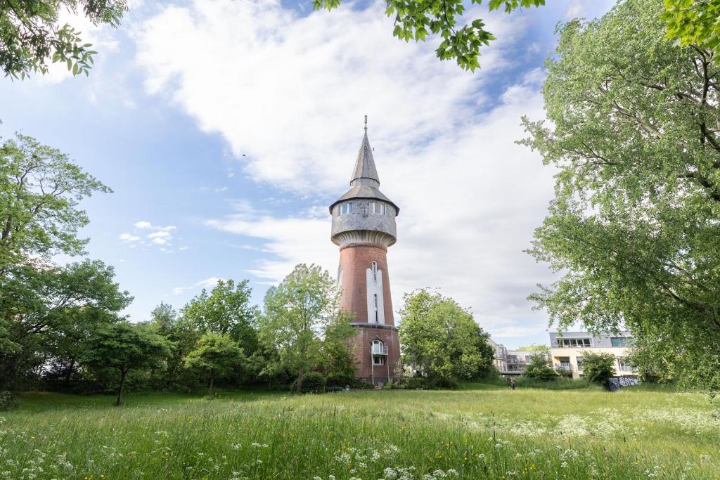 una torre de ladrillo alta en un campo con árboles en Husumer Wasserturm - Fewo 2, en Husum