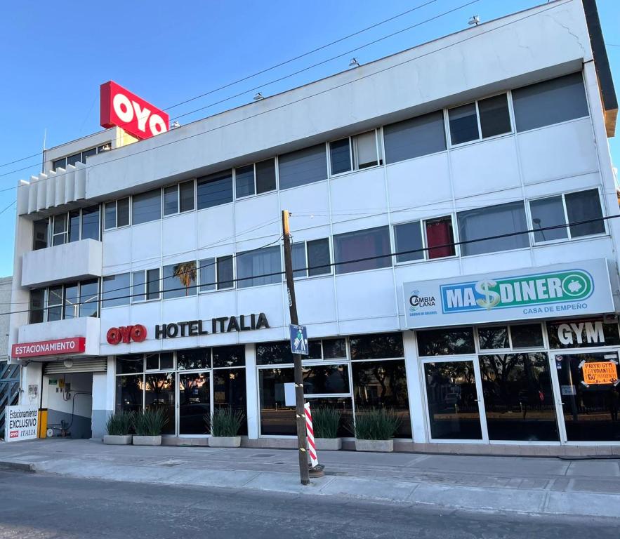 阿瓜斯卡連特斯的住宿－Hotel Italia，街道角落上一座白色的大建筑