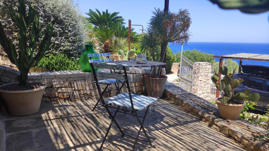 um pátio com duas cadeiras e uma mesa e algumas plantas em Mini Suite (without kitchen) - Casa Vacanze De Vita - Amazing view on the coast em Marina Serra
